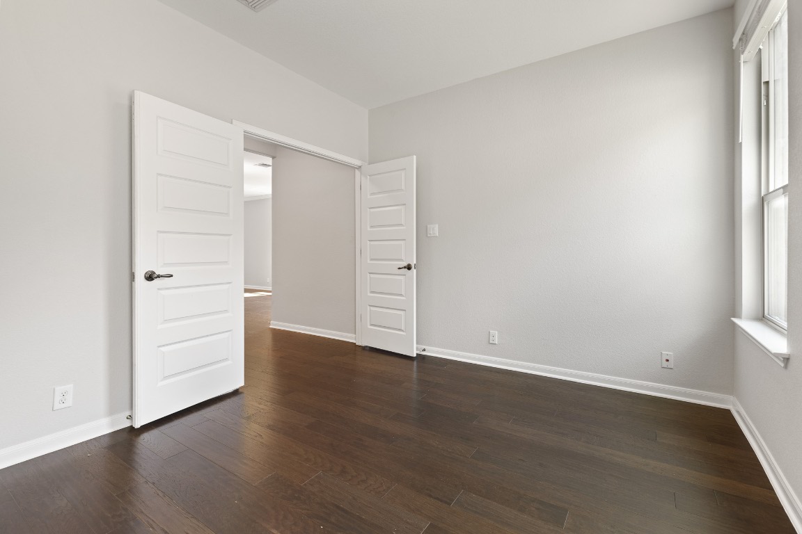 506 Hummingbird Lane, Unit A Austin, TX 78734 - Photo 11 of 36 an empty room with wooden floor cabinet and windows