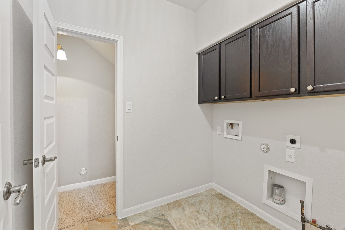 506 Hummingbird Lane, Unit A Austin, TX 78734 - Photo 13 of 36 Laundry area with hookup for a gas dryer, cabinet space, washer hookup, and electric dryer hookup