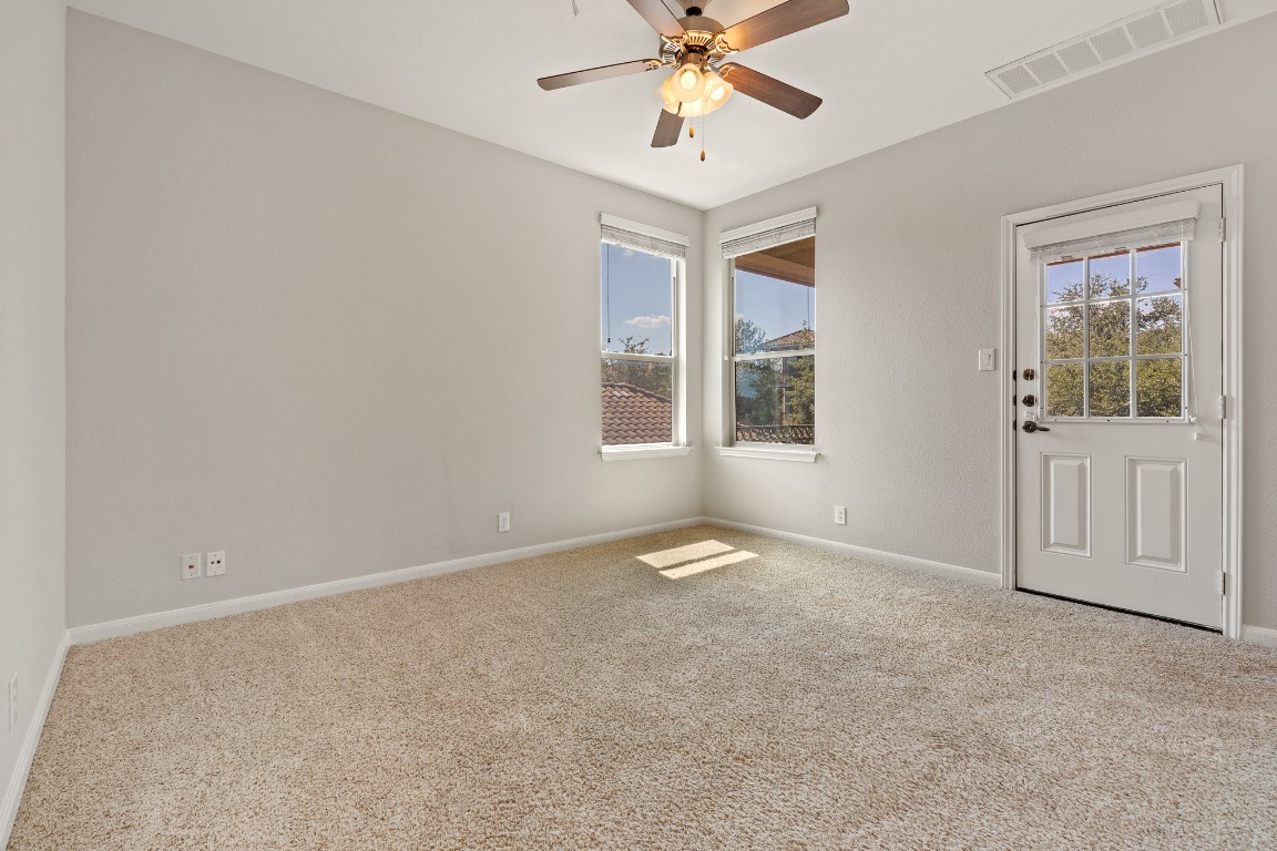 506 Hummingbird Lane, Unit A Austin, TX 78734 - Photo 15 of 36 an empty room with windows and fan