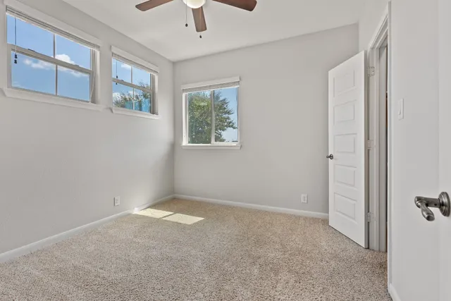 a view of a livingroom with a ceiling fan and window