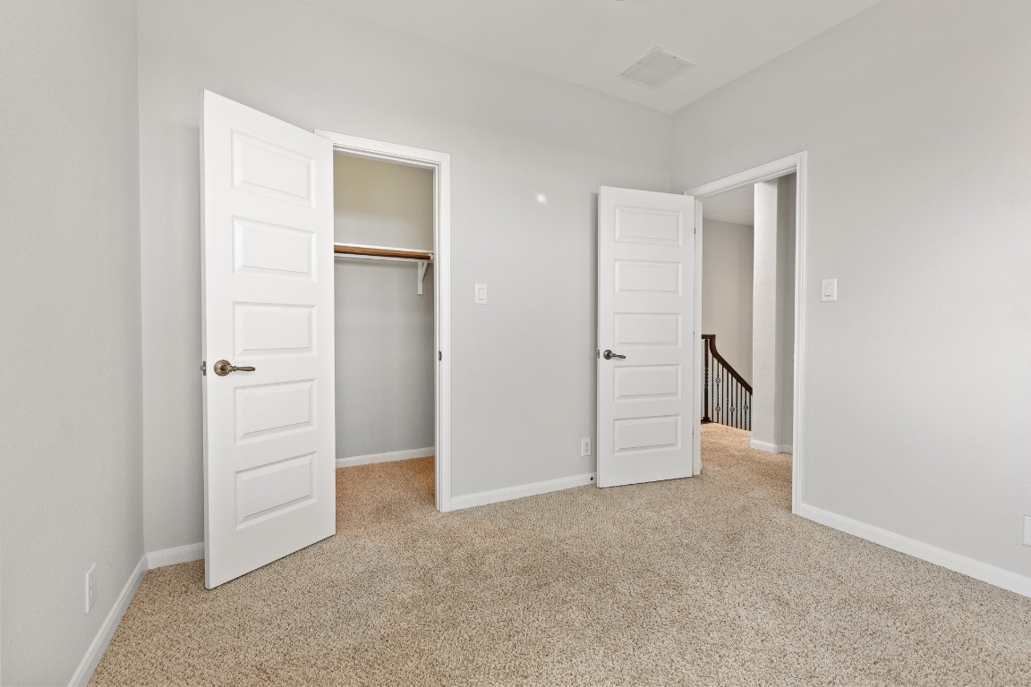 506 Hummingbird Lane, Unit A Austin, TX 78734 - Photo 18 of 36 Unfurnished bedroom featuring light carpet and a spacious closet