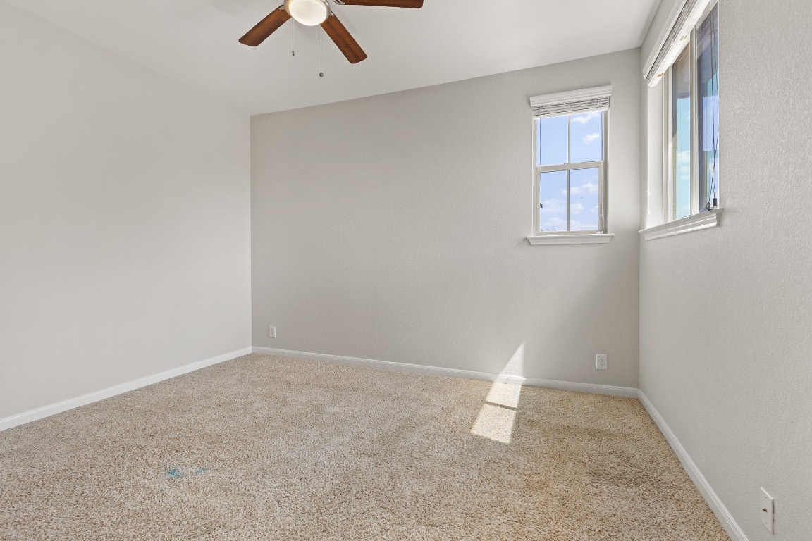 506 Hummingbird Lane, Unit A Austin, TX 78734 - Photo 21 of 36 Carpeted empty room featuring baseboards and ceiling fan