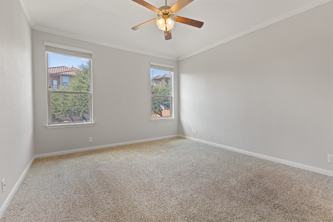 506 Hummingbird Lane, Unit A Austin, TX 78734 - Photo 24 of 36 Unfurnished room featuring crown molding, carpet floors, and a ceiling fan