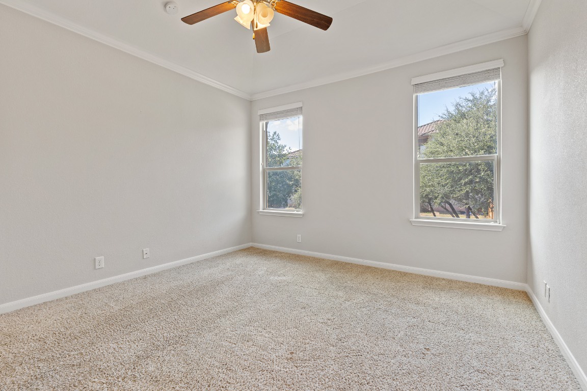 506 Hummingbird Lane, Unit A Austin, TX 78734 - Photo 26 of 36 en empty room with windows and chandelier fan