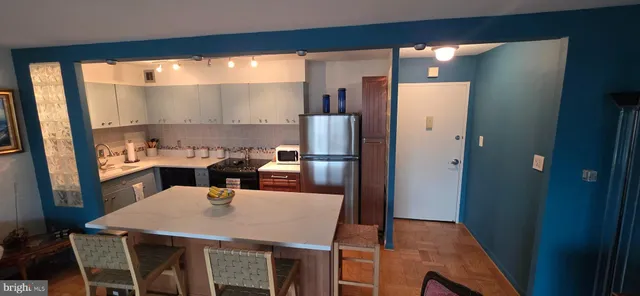 a kitchen with a table chairs and refrigerator