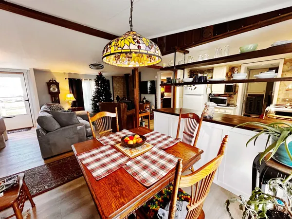 a view of a dining room with furniture a chandelier and wooden floor