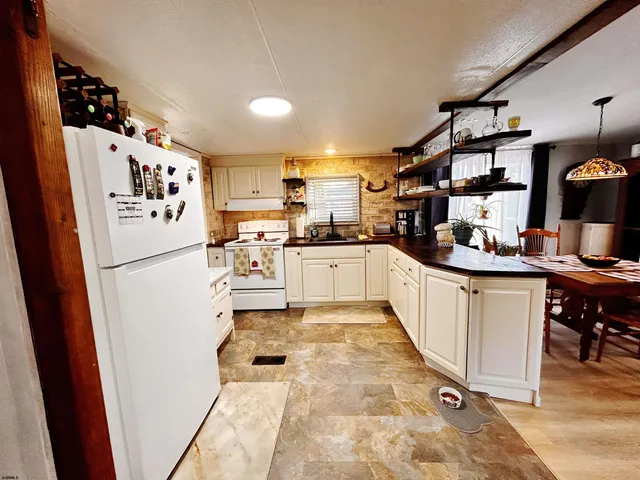 a kitchen with granite countertop a refrigerator and a sink