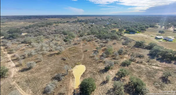 an aerial view of house with yard and mountain view in back