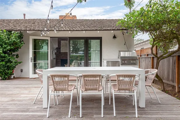 a roof deck with table and chairs and wooden floor