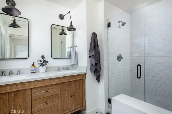 a bathroom with a double vanity sink toilet and shower