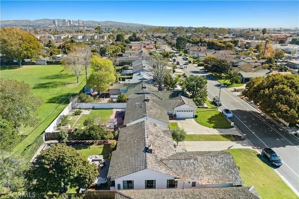 an aerial view of residential houses with outdoor space and swimming pool