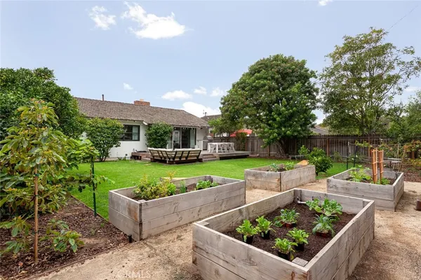 a view of a garden with couches under an umbrella