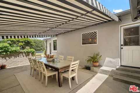 a view of a patio with a table and chairs and potted plants
