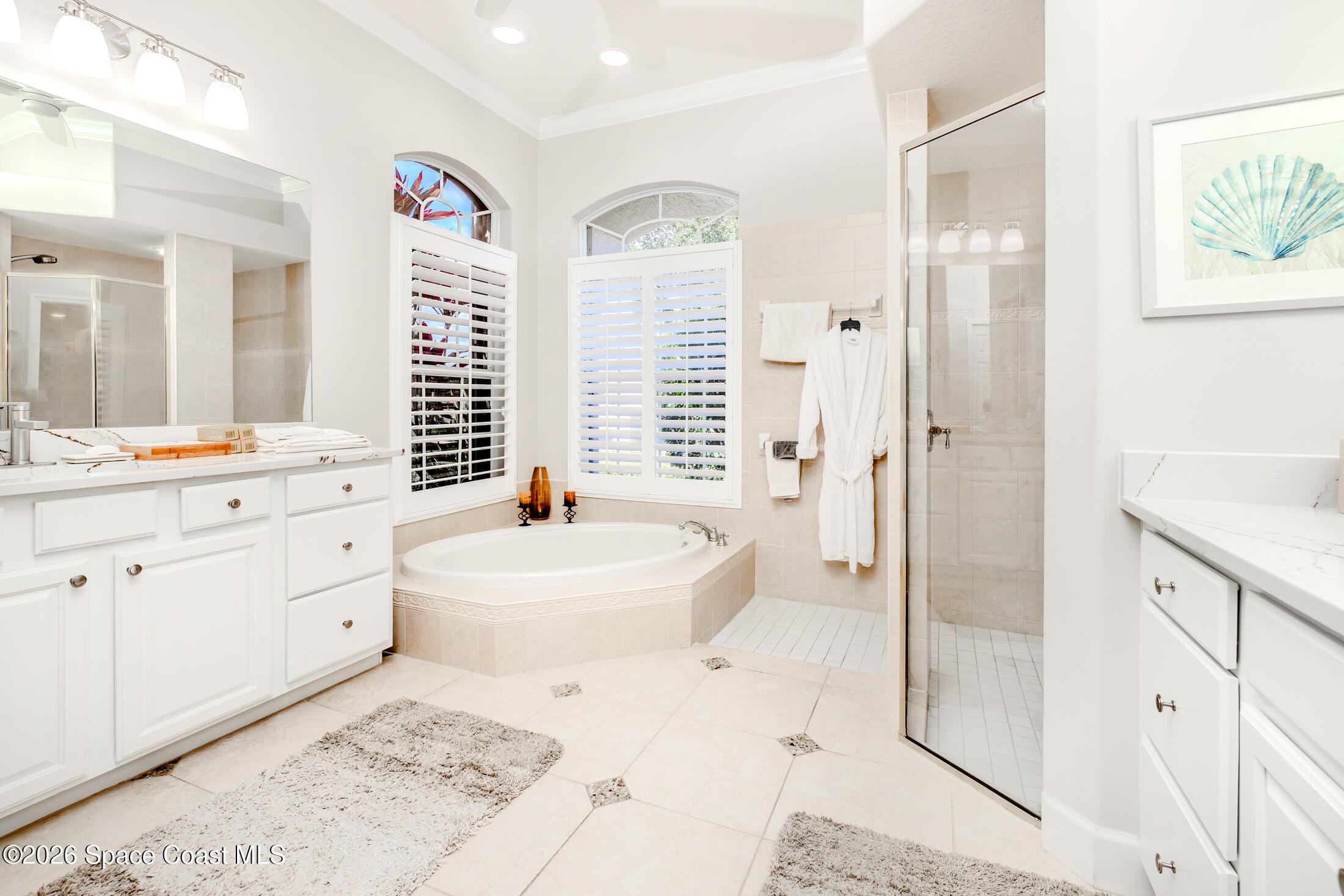 8201 Compton Way Melbourne, FL 32940 - Photo 28 of 52 a spacious bathroom with a double vanity sink a mirror a bathtub and next to a window
