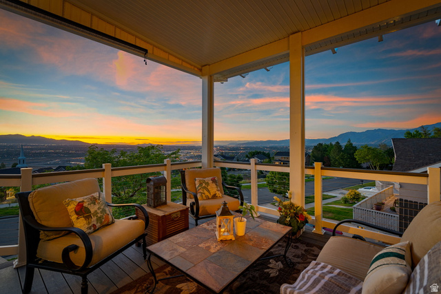 14883 Tooele Lane Draper, UT 84020 - Photo 1 of 49 Covered outdoor deck with panoramic mountain and valley scenery, featuring white railings and a dark wood-finish floor