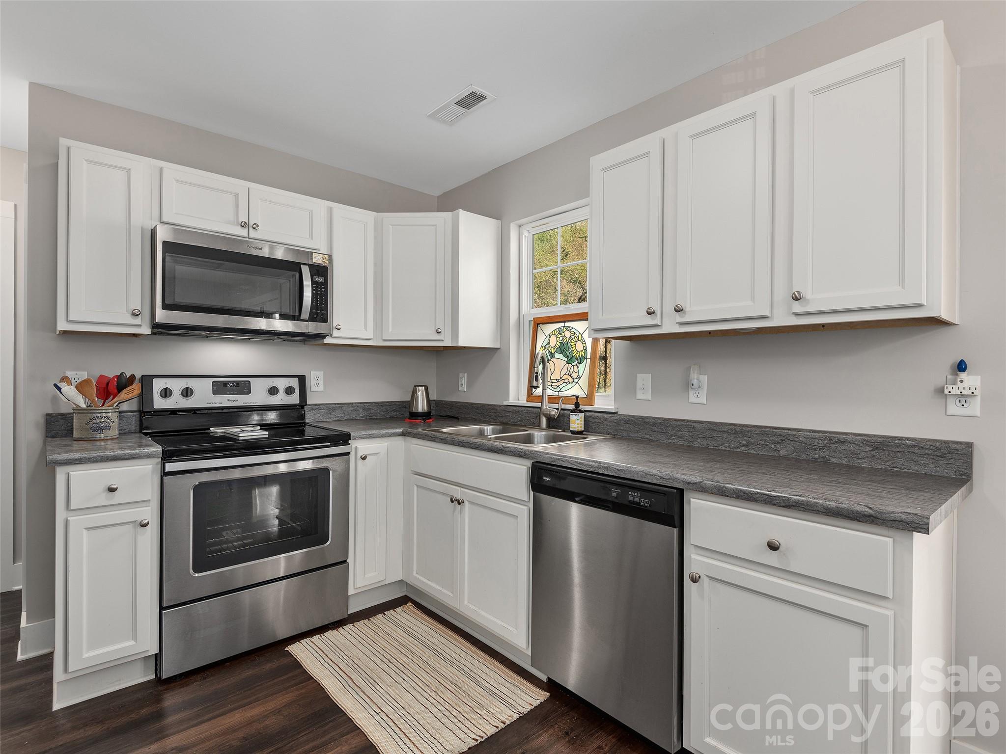 201 Stoney Point Way Candler, NC 28715 - Photo 9 of 18 a kitchen with granite countertop a stove a sink and a microwave