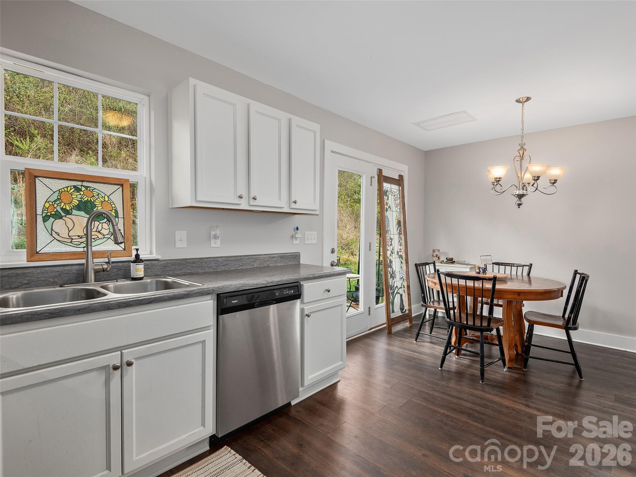 201 Stoney Point Way Candler, NC 28715 - Photo 10 of 18 a kitchen with stainless steel appliances granite countertop a dining table chairs a sink and dishwasher a refrigerator with wooden floor