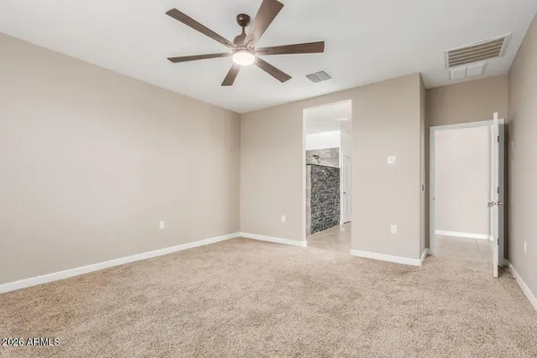 an empty room with closet and a ceiling fan