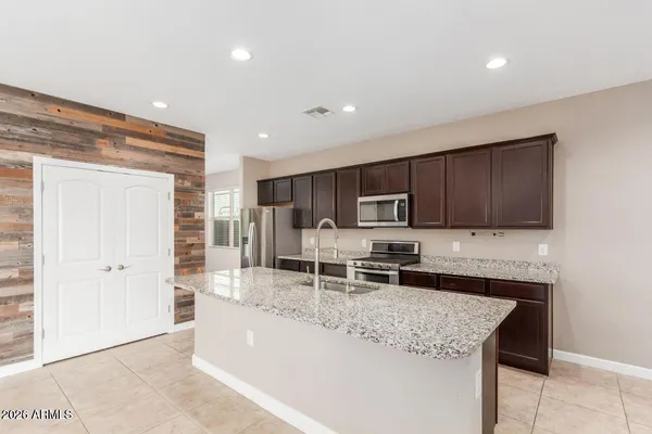 a kitchen with stainless steel appliances granite countertop a sink stove and cabinets