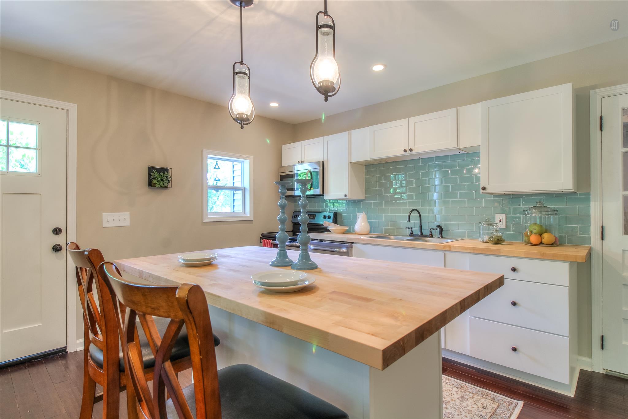 304 Warrior Road Madison, TN 37115 - Photo 6 of 16 Designer pendants hang over the butcher block topped island.