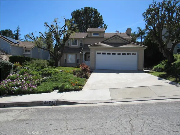 a view of a house with a yard and potted plants