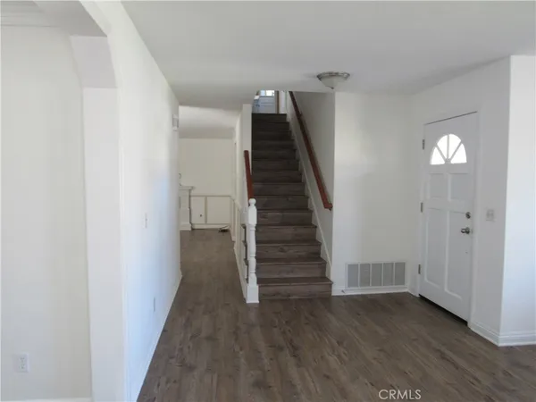 a view of a hallway with wooden floor and entryway