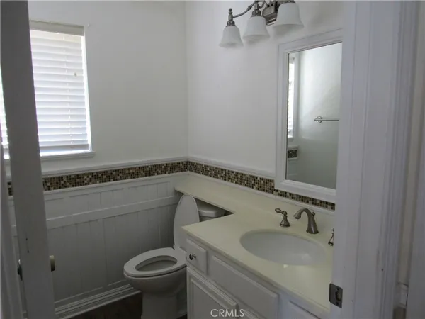 a bathroom with a sink toilet and mirror
