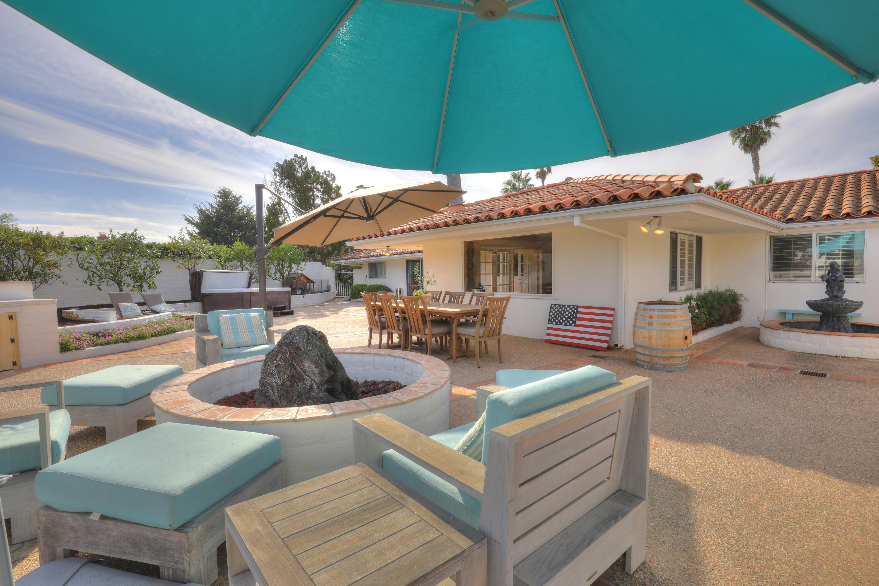 4620 Via Rubi Santa Barbara, CA 93105 - Photo 7 of 18 a view of a patio with couches table and chairs under an umbrella