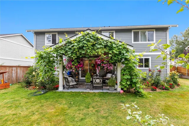 a backyard of a house with table and chairs plants