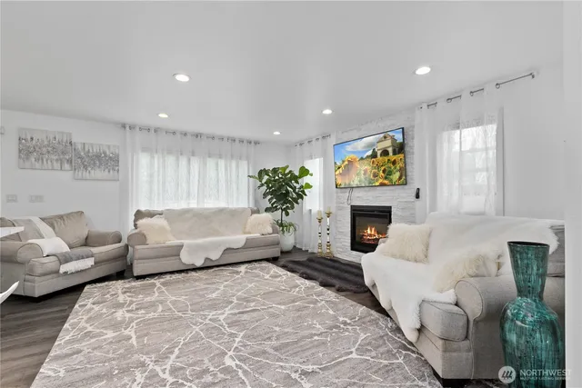 a living room with furniture a fireplace and a chandelier