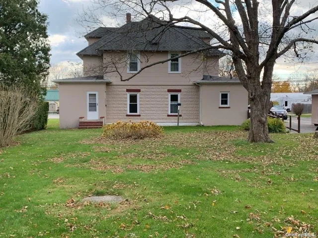 a front view of house with yard and trees