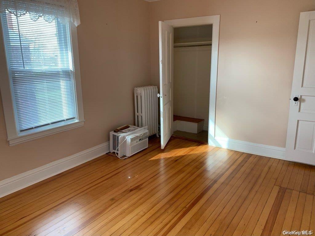 775 Hummel Avenue, Unit A Southold, NY 11971 - Photo 8 of 11 an empty room with wooden floor and windows
