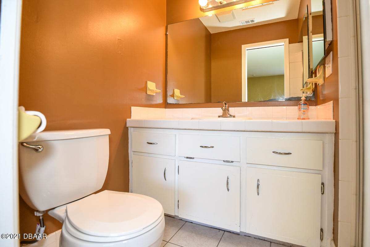 25 Tula Drive Port Orange, FL 32129 - Photo 32 of 49 a bathroom with a granite countertop toilet sink and mirror