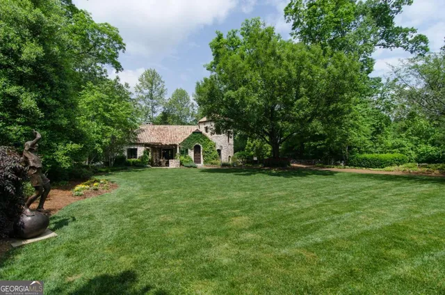 a front view of a house with a yard and potted plants