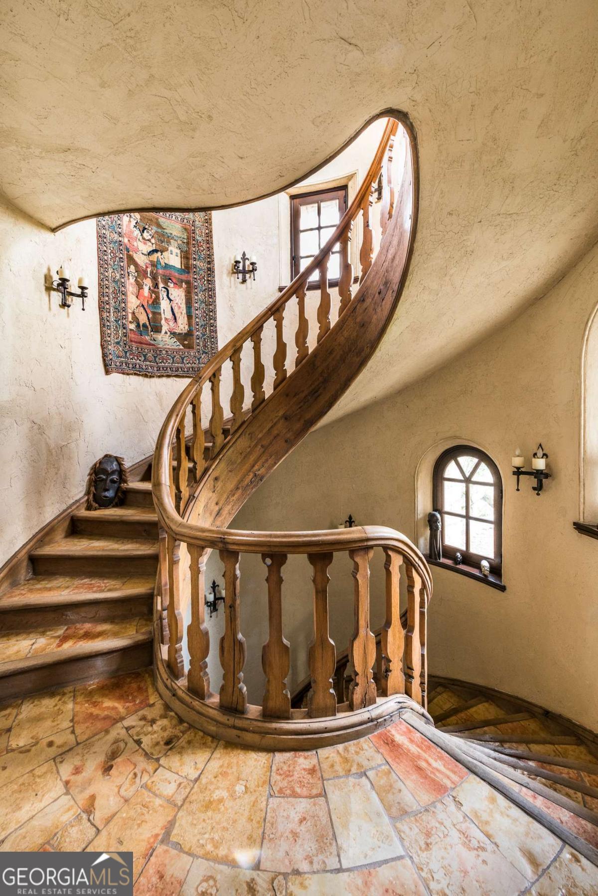 2100 West Wesley Road Northwest Atlanta, GA 30327 - Photo 25 of 53 a view of staircase with a metal railing and a chandelier