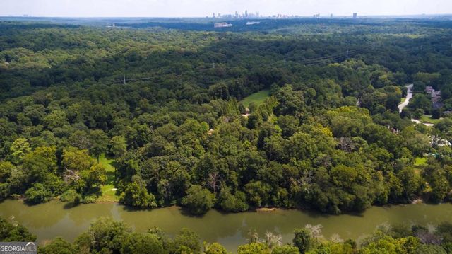 an aerial view of a houses with a lush green forest