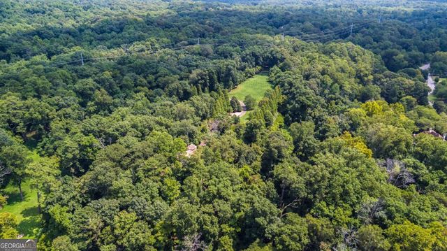 a view of a house with a lush green forest