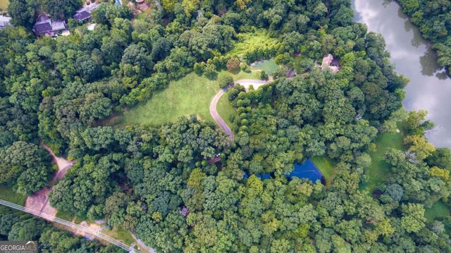 an aerial view of a house with a yard and lake view