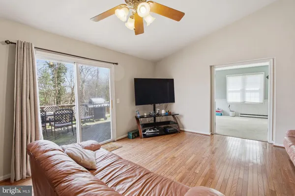 a living room with furniture and a flat screen tv with wooden floor