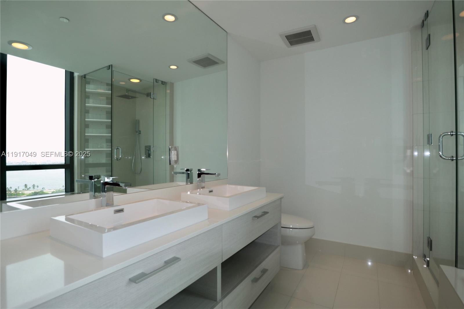 650 Northeast 32nd Street, Unit 1207 Miami, FL 33137 - Photo 11 of 30 a bathroom with a sink double vanity and a mirror
