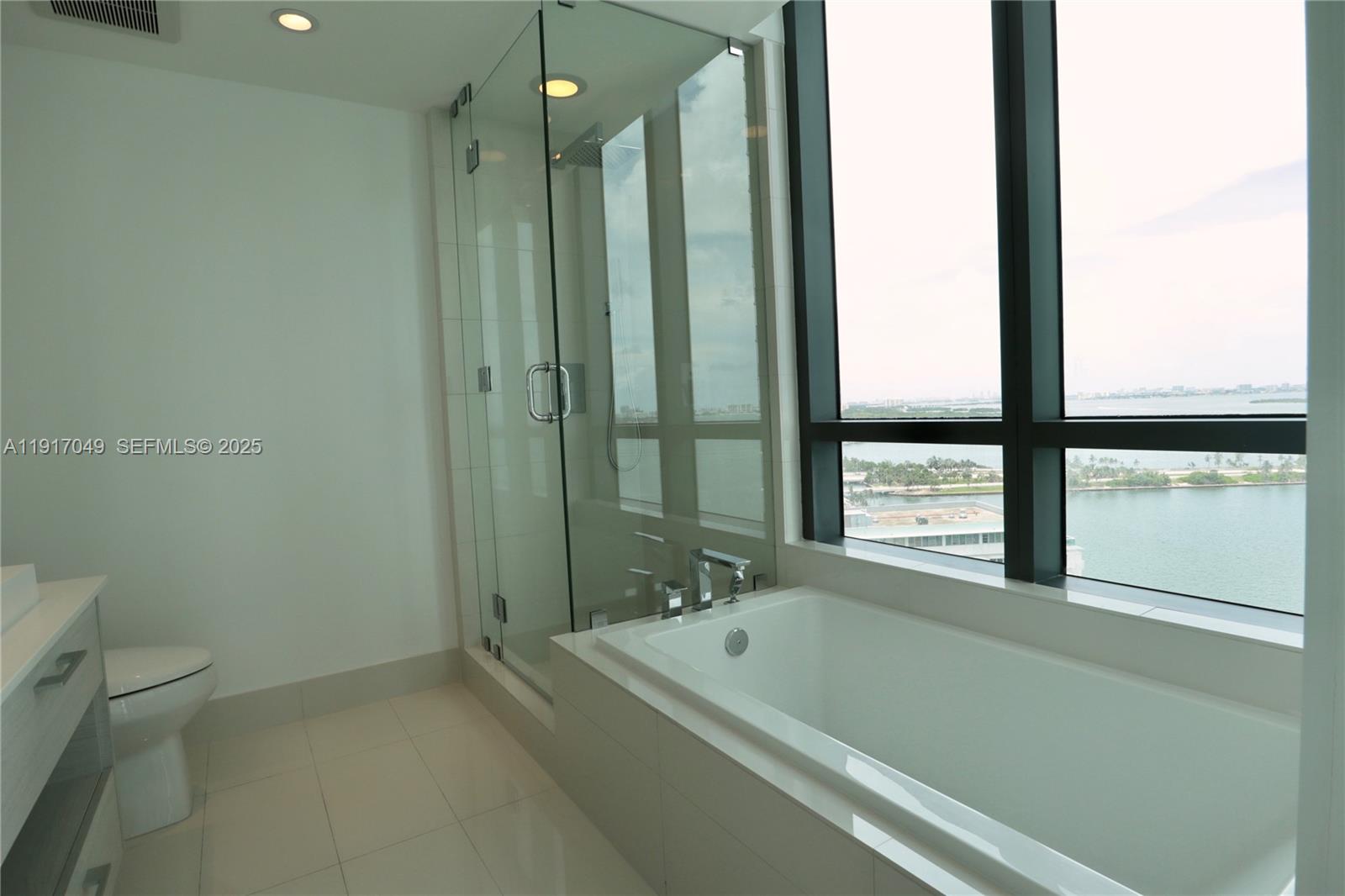 650 Northeast 32nd Street, Unit 1207 Miami, FL 33137 - Photo 12 of 30 a bathroom with a tub a toilet and a shower