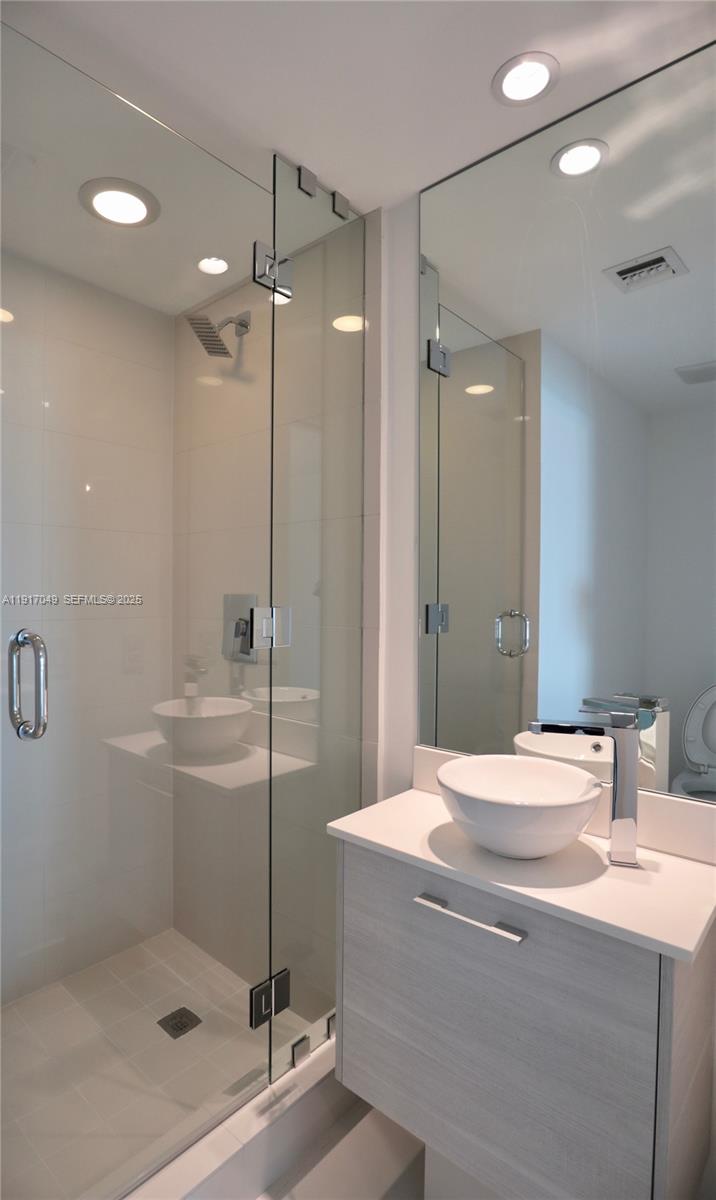 650 Northeast 32nd Street, Unit 1207 Miami, FL 33137 - Photo 15 of 30 a bathroom with a shower sink and mirror