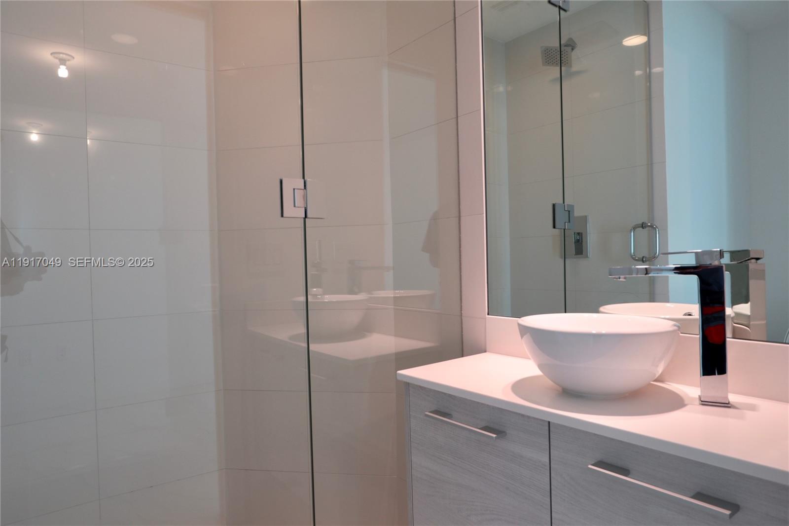 650 Northeast 32nd Street, Unit 1207 Miami, FL 33137 - Photo 16 of 30 a bathroom with a sink a toilet and shower