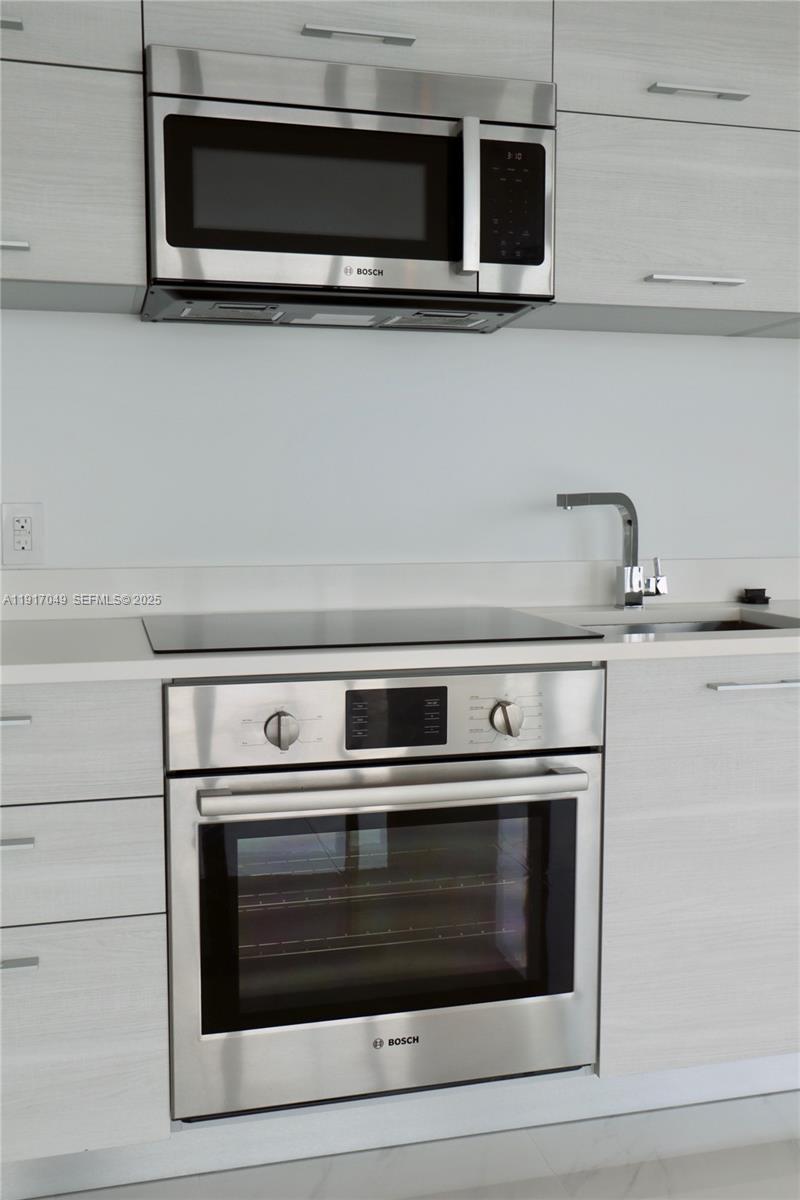 650 Northeast 32nd Street, Unit 1207 Miami, FL 33137 - Photo 18 of 30 a stove top oven sitting inside of a kitchen