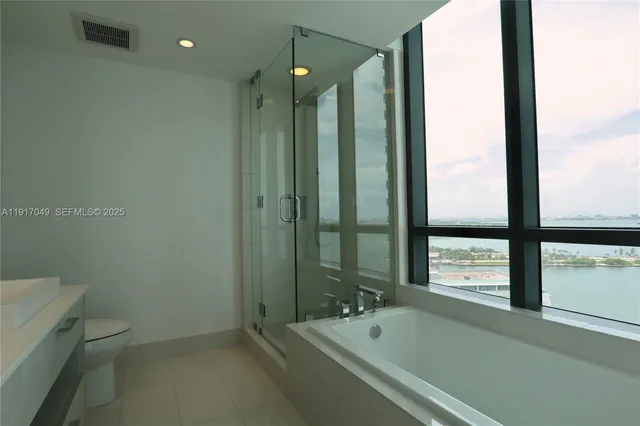a bathroom with a tub a toilet and a shower
