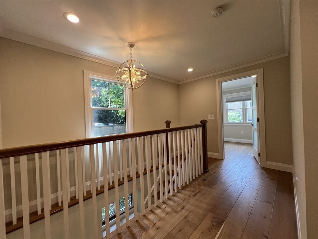 23 Winslow Road, Unit 1 Brookline, MA 02446 - Photo 14 of 27 a view of a hallway with wooden floor and windows