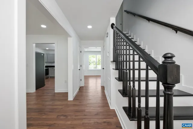 a view of a hallway with wooden floor and stairs