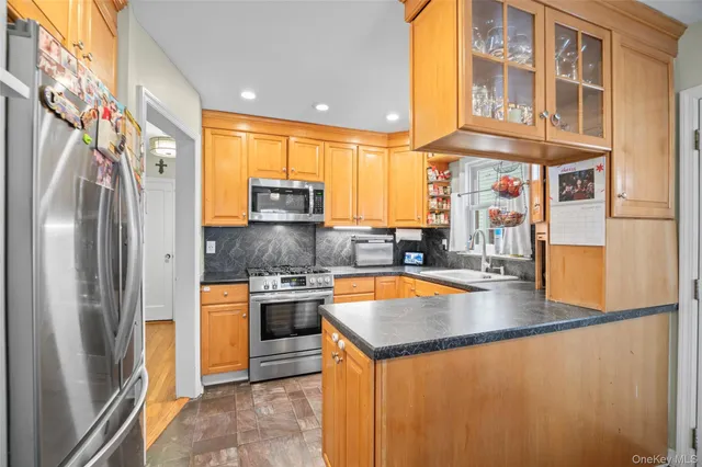 a kitchen with stainless steel appliances granite countertop a sink a stove and a refrigerator
