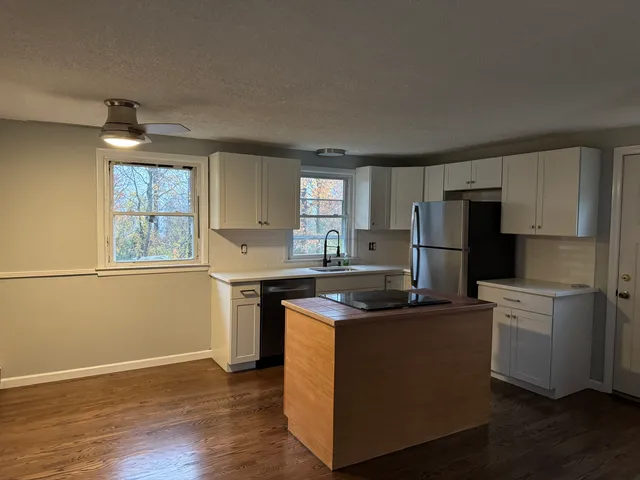 a kitchen with kitchen island a sink stove and refrigerator