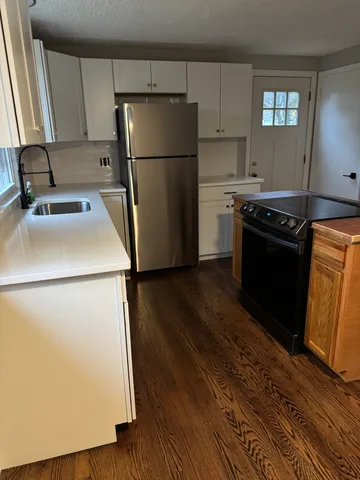 a kitchen with a refrigerator sink stove and cabinets